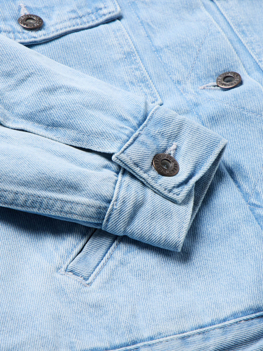 Light wash denim jacket with flap chest pocket and metal snap buttons