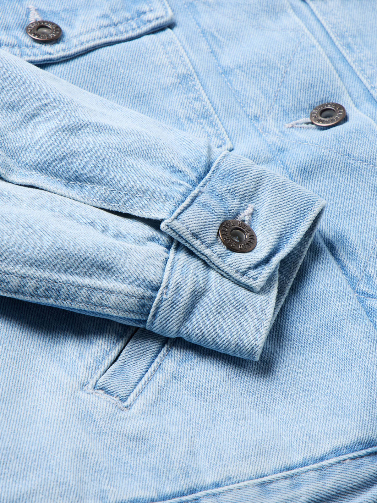 Light wash denim jacket with flap chest pocket and metal snap buttons