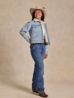 Sherpa-lined light wash denim jacket worn by a model with a tan hat