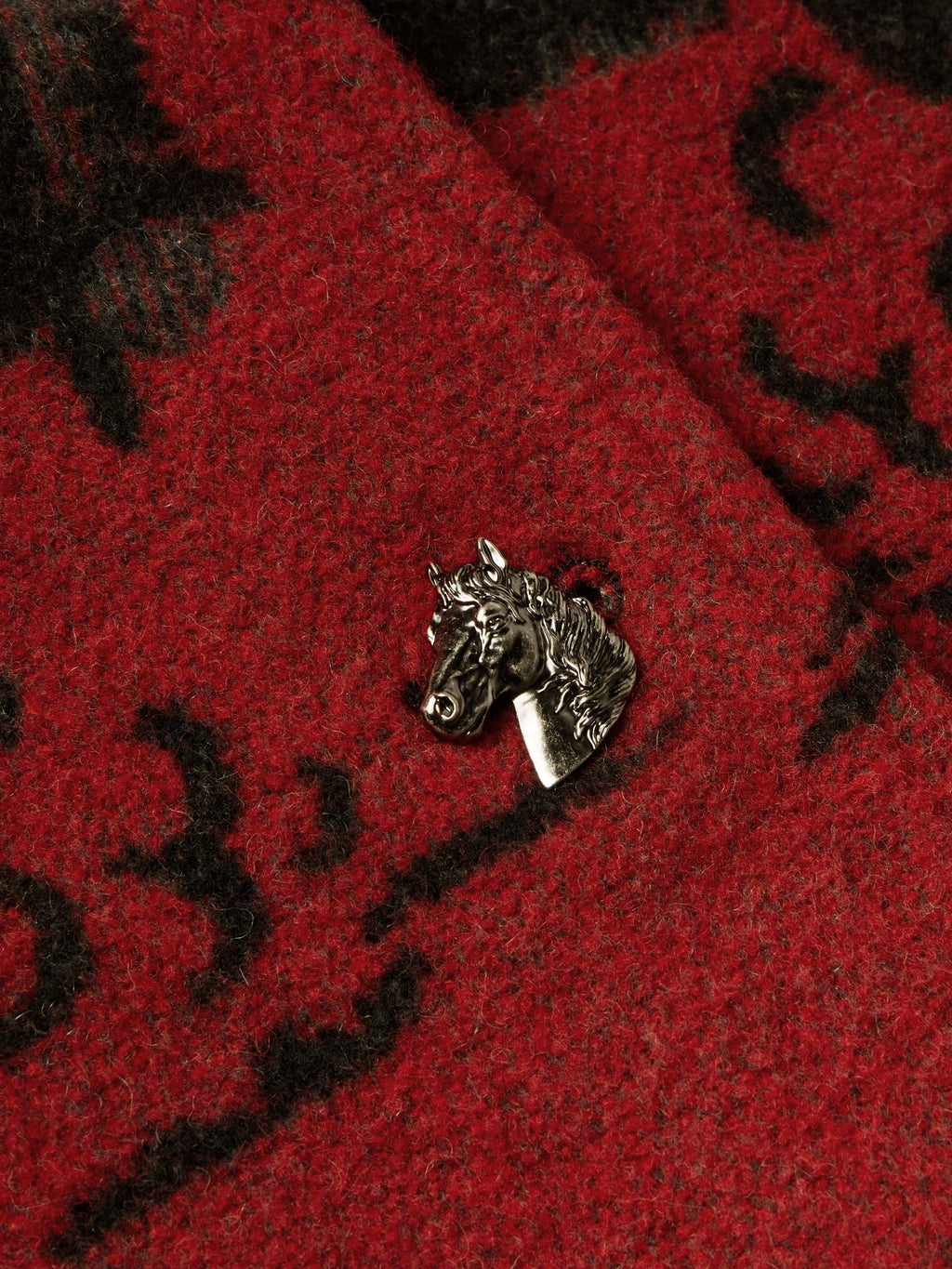 Crimson and dark gray blanket-style coat with metallic animal-shaped button clasp