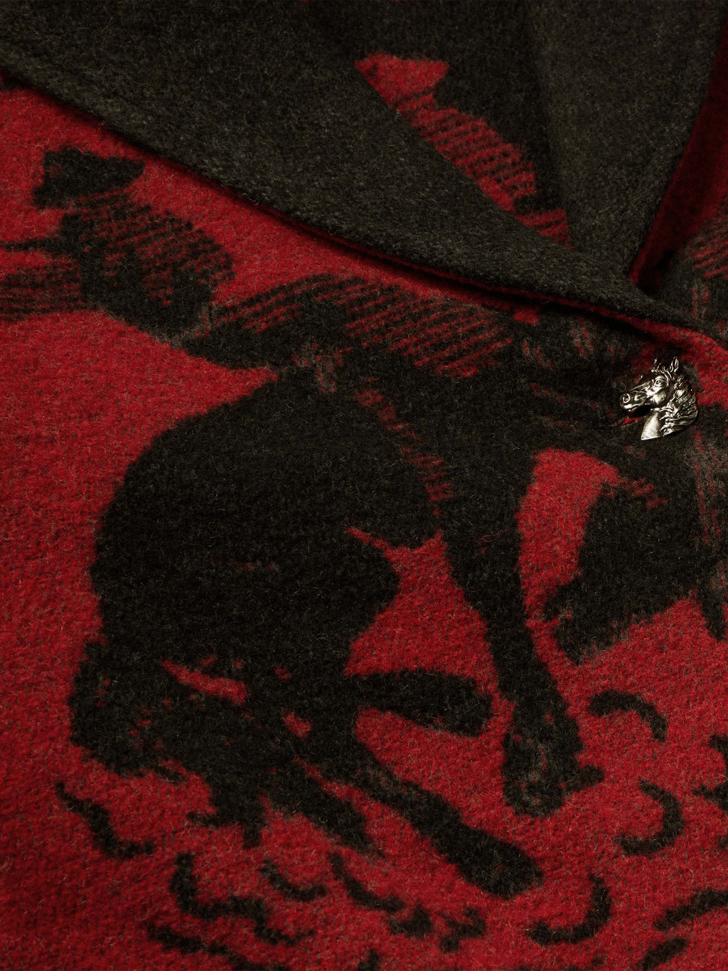 Front of crimson and dark gray blanket-style coat with ornate metal closure