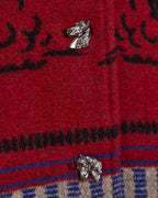 Crimson red blanket coat fabric close-up with horse-head patch and blue trim.