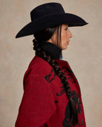 Women’s crimson red blanket coat with black collar and animal print near shoulder.