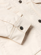 Natural drifter coat fabric detail; stitched flap pocket with round logo buttons