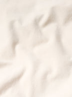 Natural drifter coat fabric close-up; smooth off-white textile with subtle texture