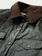 Dark green barn coat collar in brown with snap placket and gold-toned buttons, close-up.