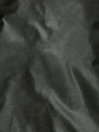 Loden dark green waxed fabric close-up with textured finish and seam lines