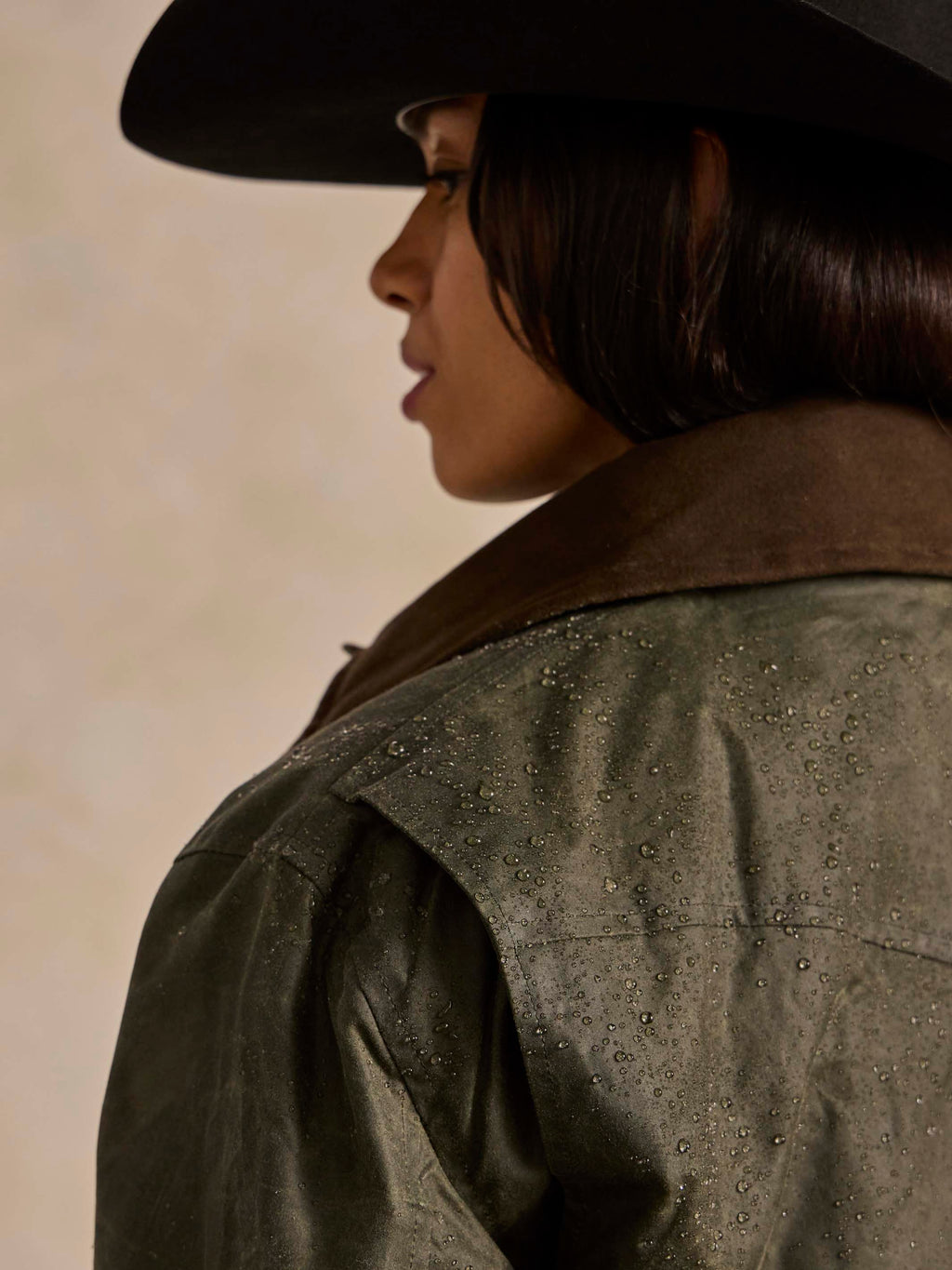 Loden dark green coat shoulder with subtle speckled texture and seam stitching