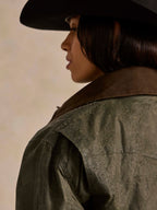 Loden dark green coat shoulder with subtle speckled texture and seam stitching