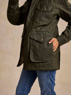 Loden green barn coat with flap pockets and metal snap closure, long sleeves