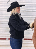 Women's black wool arena jacket on person, front zip and stand collar visible