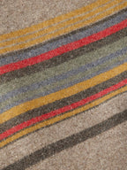 Close-up of taupe striped jacket with multicolor horizontal bands