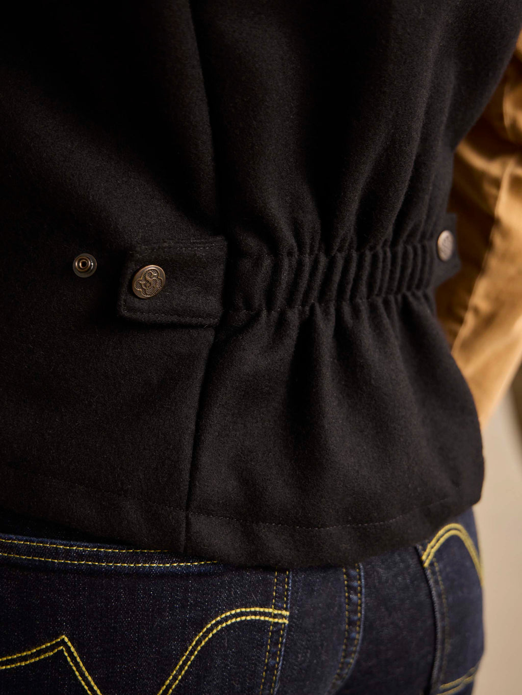 Black wool vest with snap-button placket and gathered hem