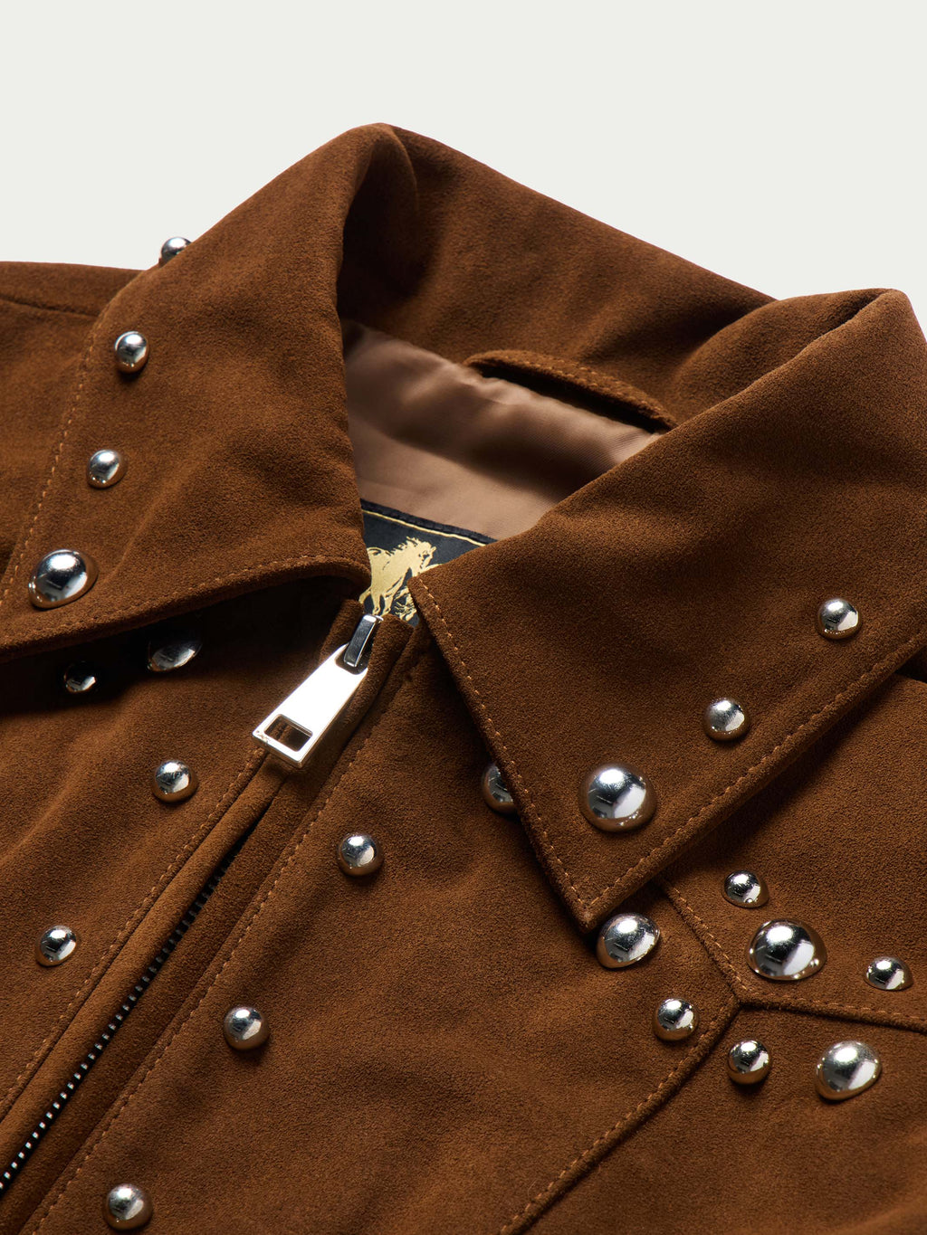 Pecan suede jacket close-up with studded shoulders, snap placket, and metal hardware