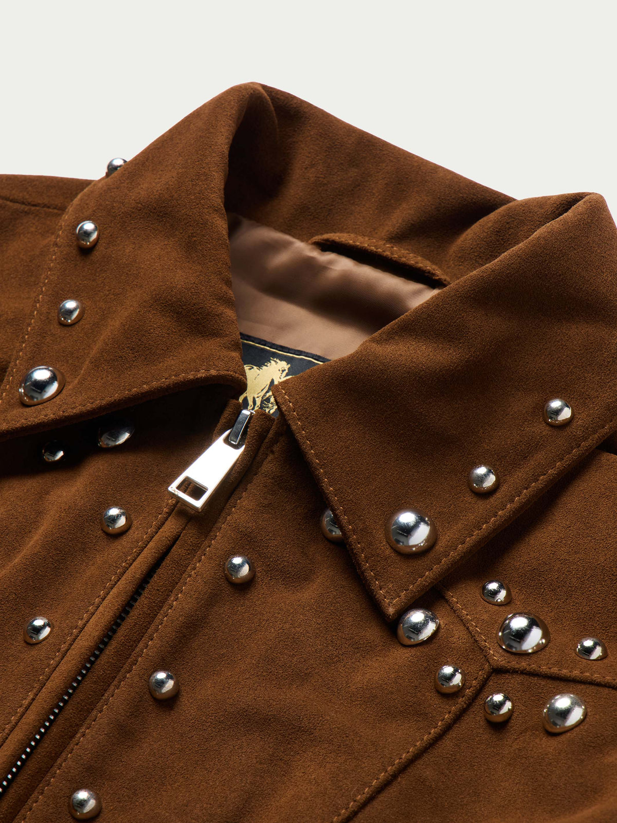Pecan suede jacket close-up with studded shoulders, snap placket, and metal hardware