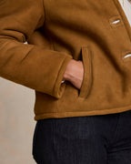 Brown shearling jacket sleeve and side hand-warmer pocket with seam stitching