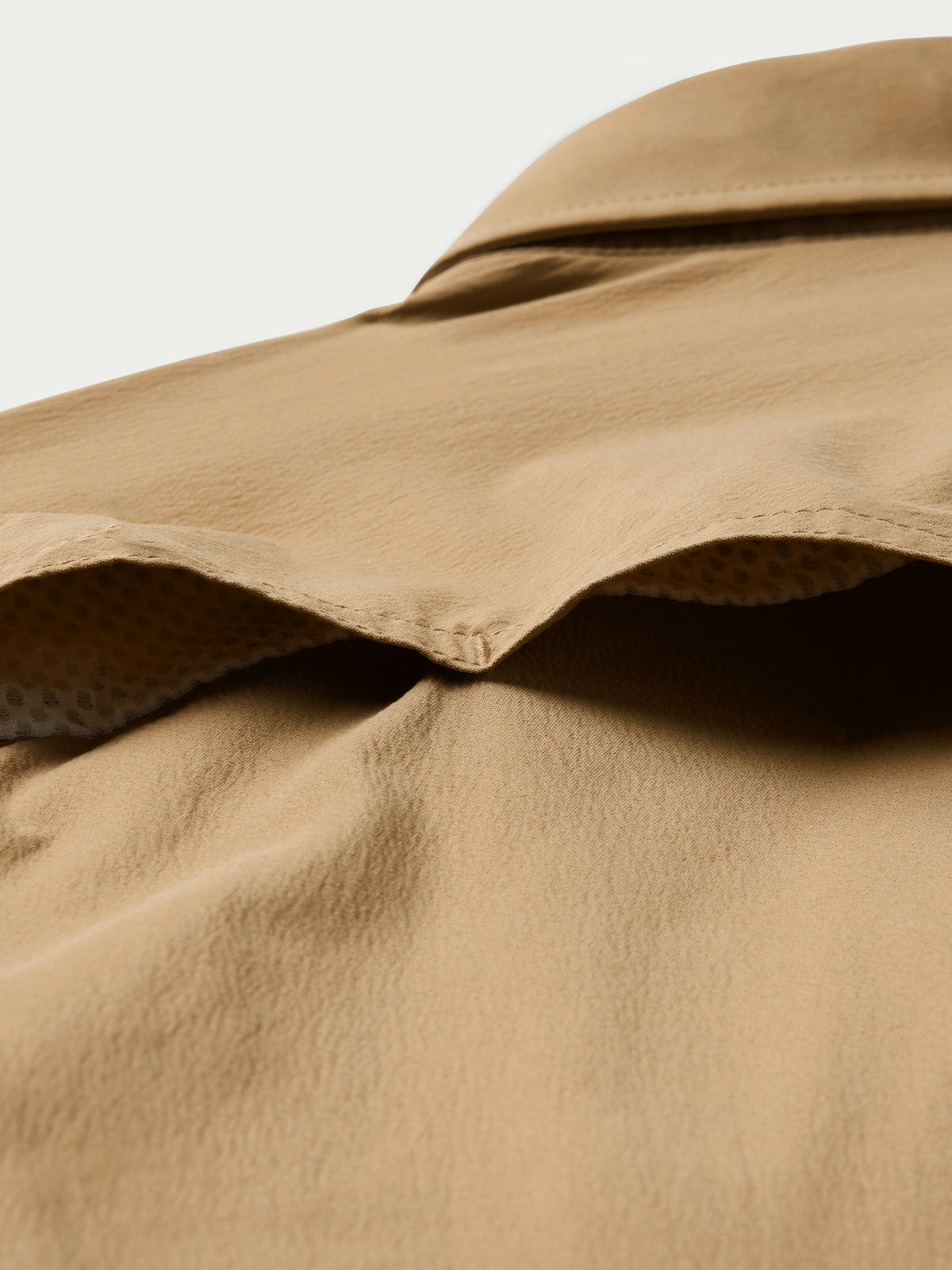 Tan snap shirt yoke and collar edge with textured fabric lining at opening
