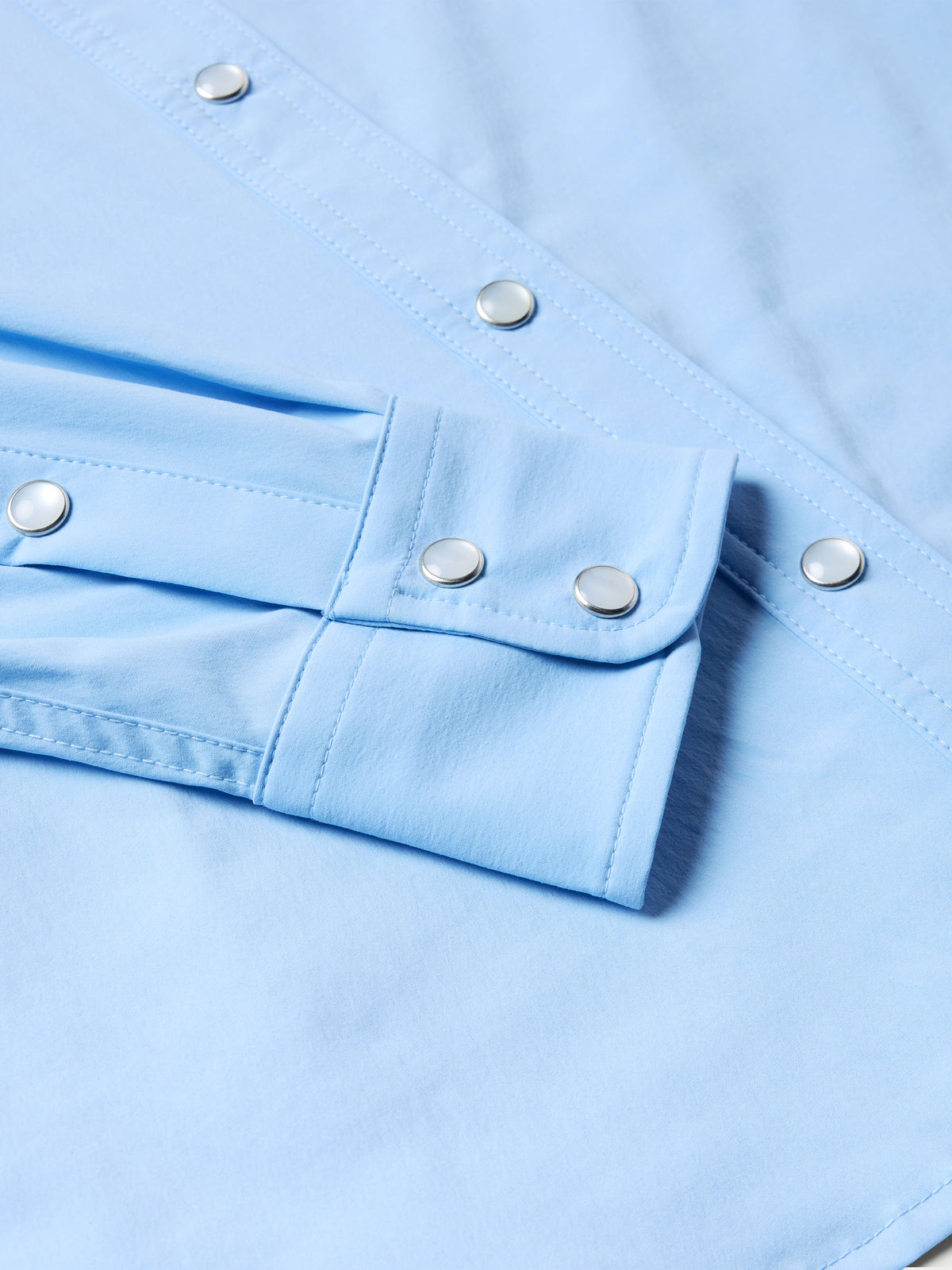 Women’s sky blue snap shirt cuff with metal snaps and adjustable placket