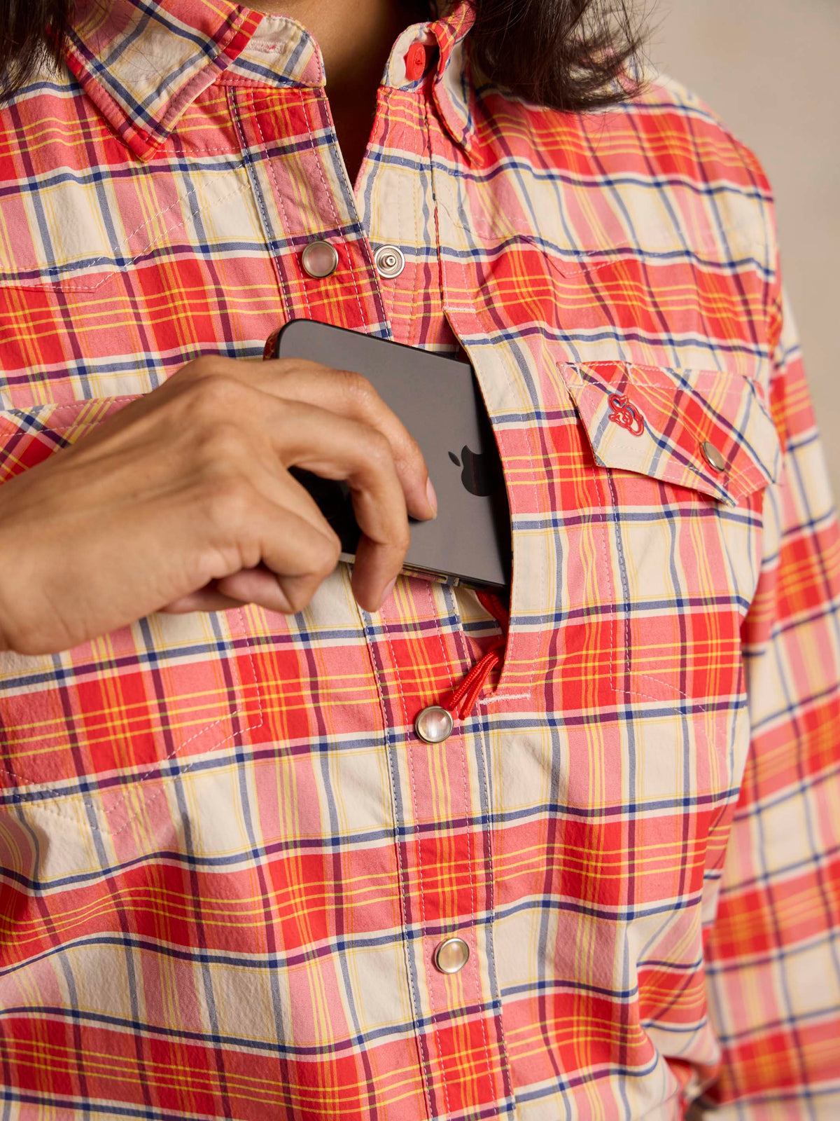 Women’s plaid snap western shirt close-up, red and white snaps on chest placket
