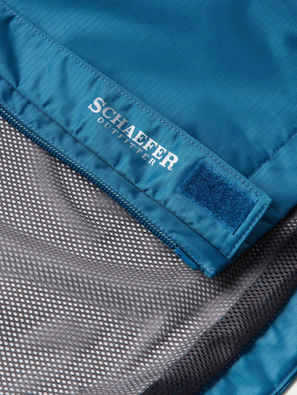Schaefer Outerwear size label on inside cuff of Baltic blue rain jacket