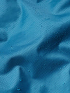 Baltic blue rain jacket shell with visible water droplets on fabric