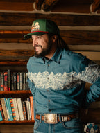 Man wearing green snapback cap with Wyoming graphic patch