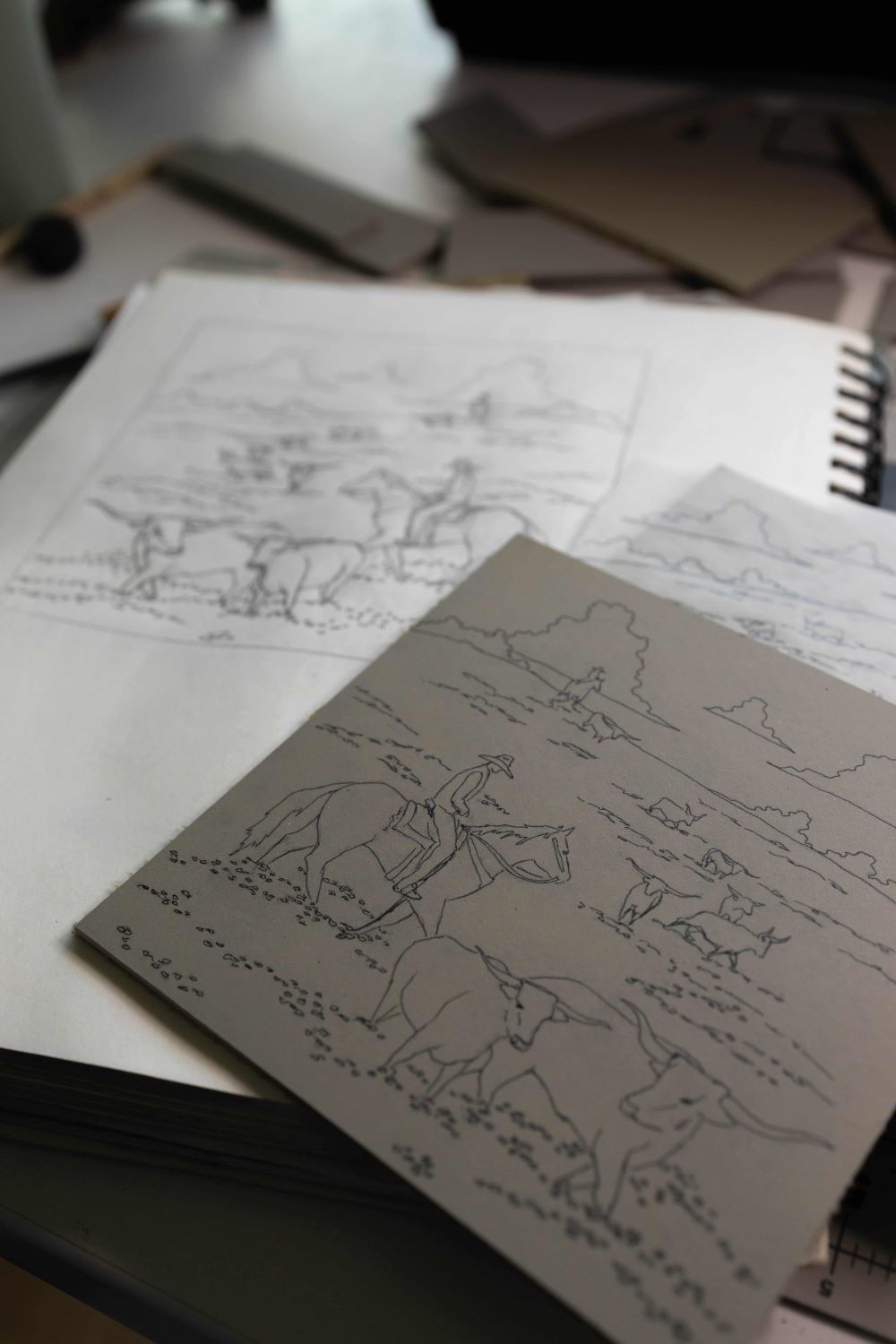 Black-and-white Western map and animal design sketches on paper.