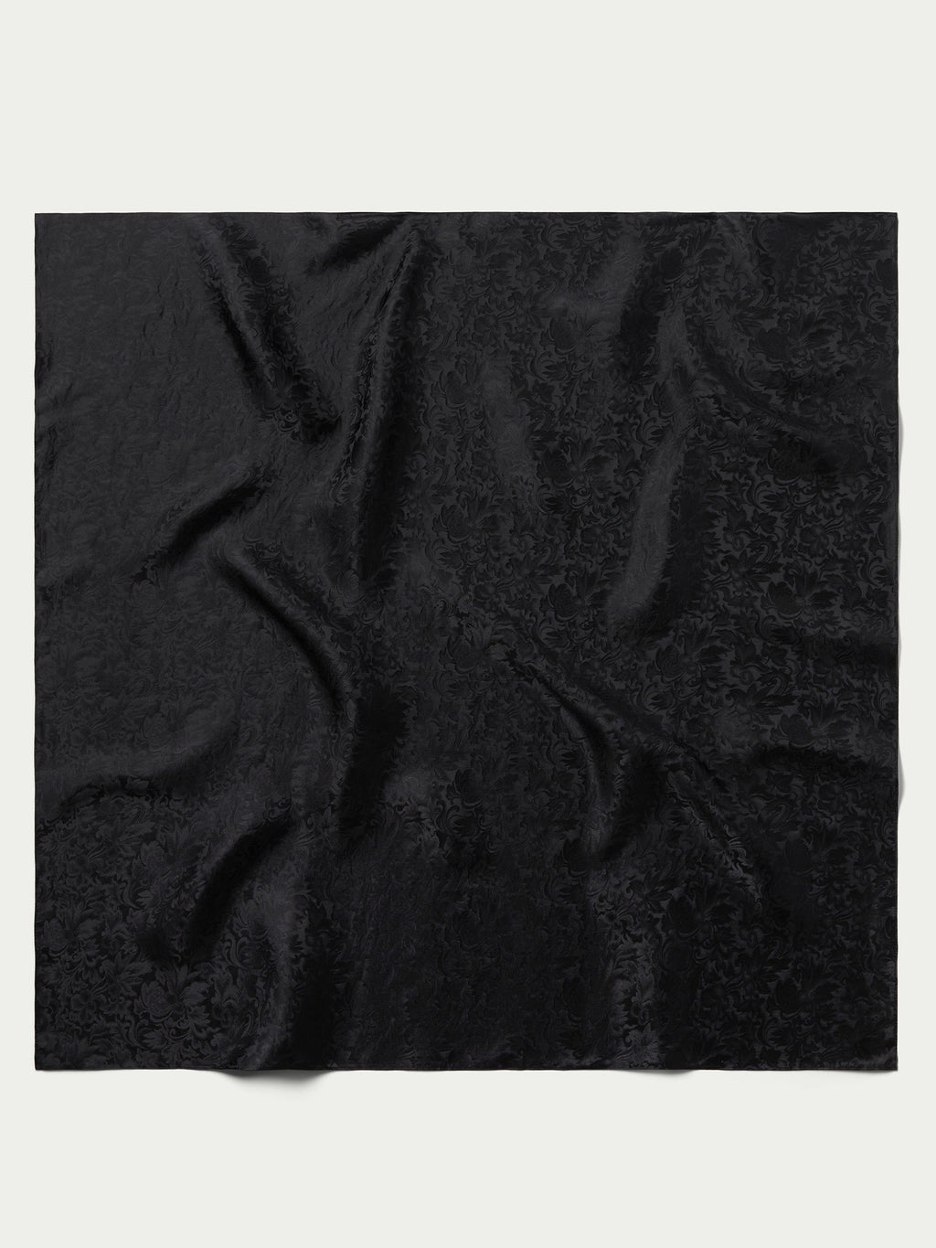 Black jacquard wild rag scarf fabric close-up with ornate swirl pattern