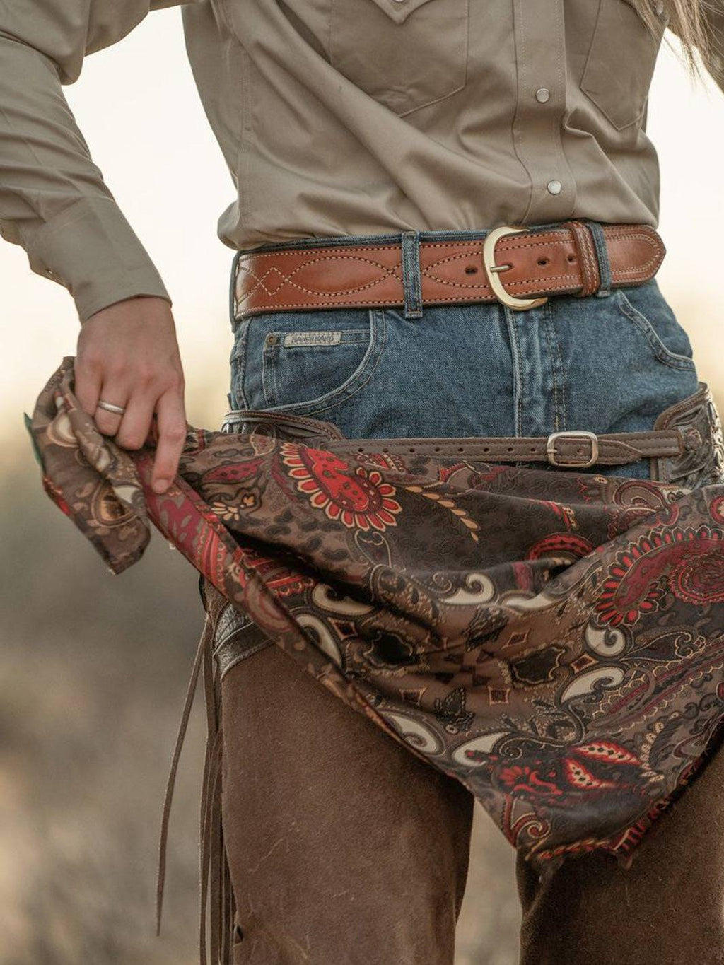 Cocoa paisley wild rag bandana with red and cream swirls, worn around waist