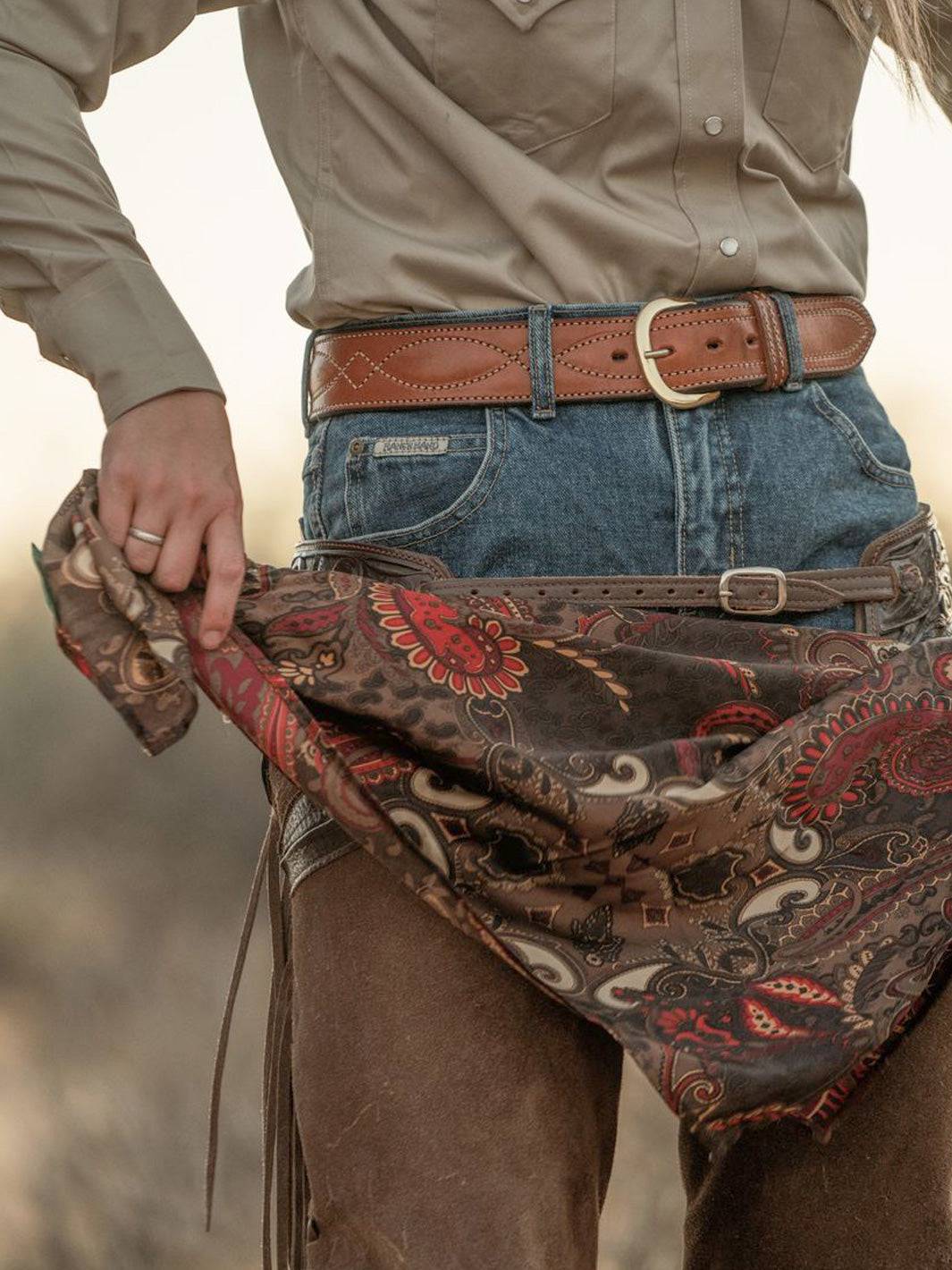 Cocoa paisley wild rag bandana with red and cream swirls, worn around waist