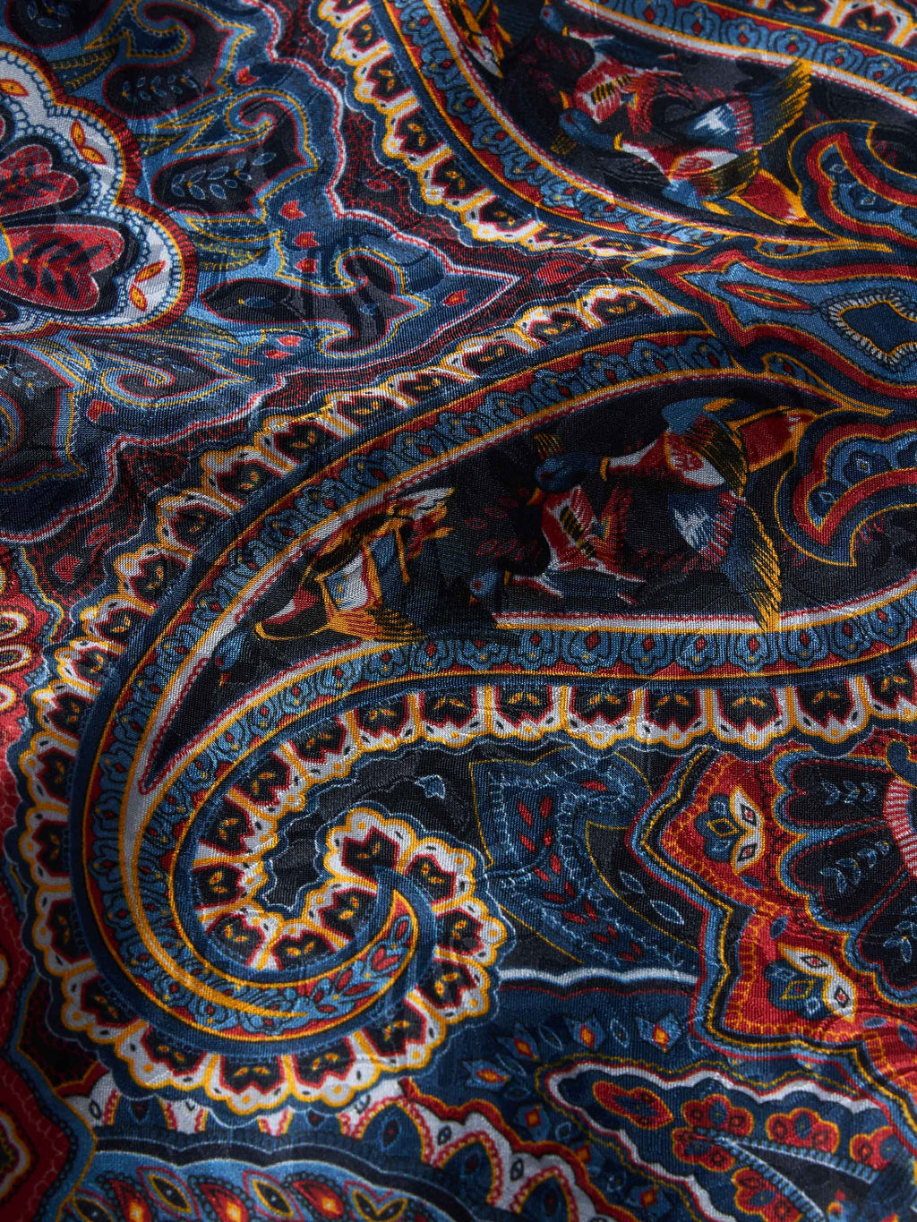 Paisley wild rag fabric close-up in navy with rust and yellow paisley details