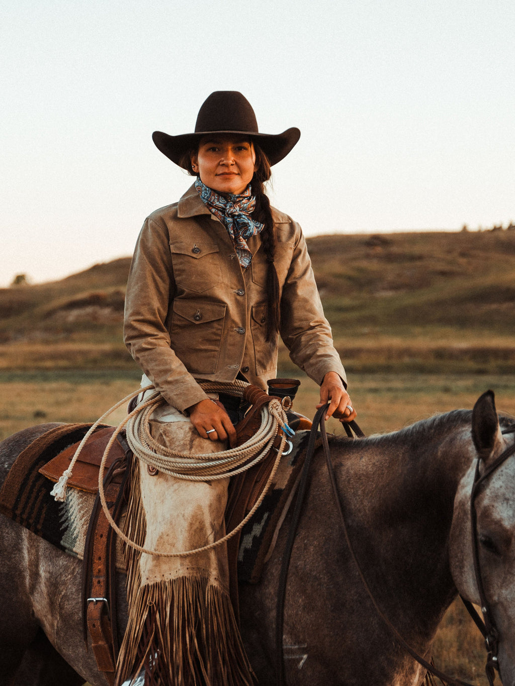 Wild rag scarf in paisley print worn on a brown outfit and cowboy hat
