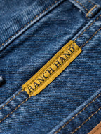 Blue denim dungarees with woven brand patch on pocket seam