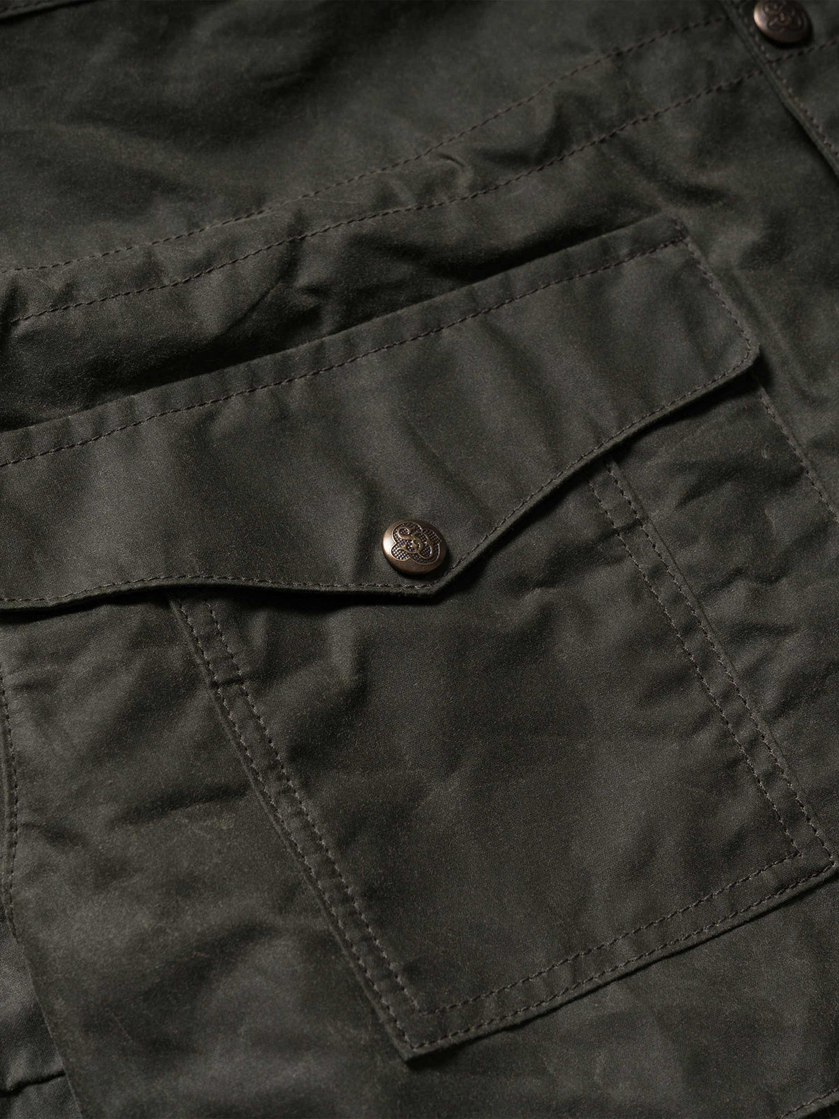 Dark green jacket close-up with button placket and stitched chest pocket flap
