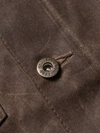 Mesquite brush jacket detail, round branded snap button on dark brown fabric