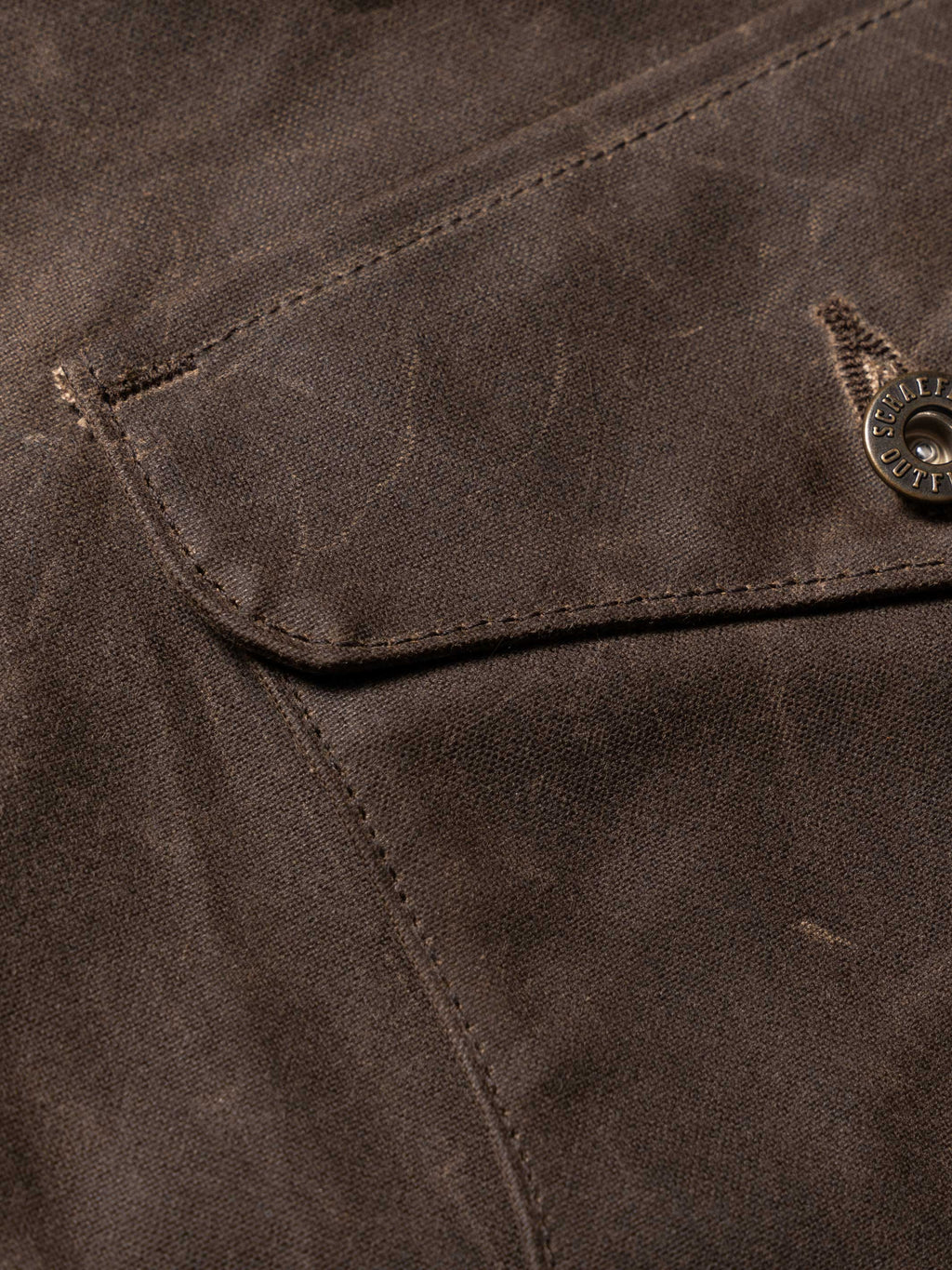 Mesquite brush jacket pocket flap and stitching detail, dark brown fabric