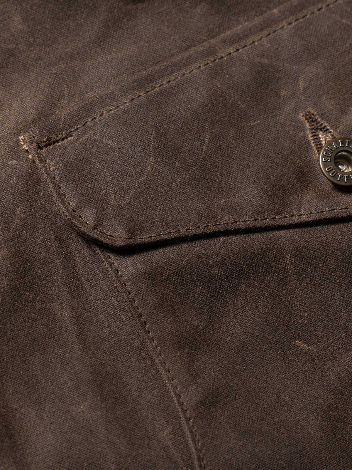 Mesquite brush jacket pocket flap and stitching detail, dark brown fabric