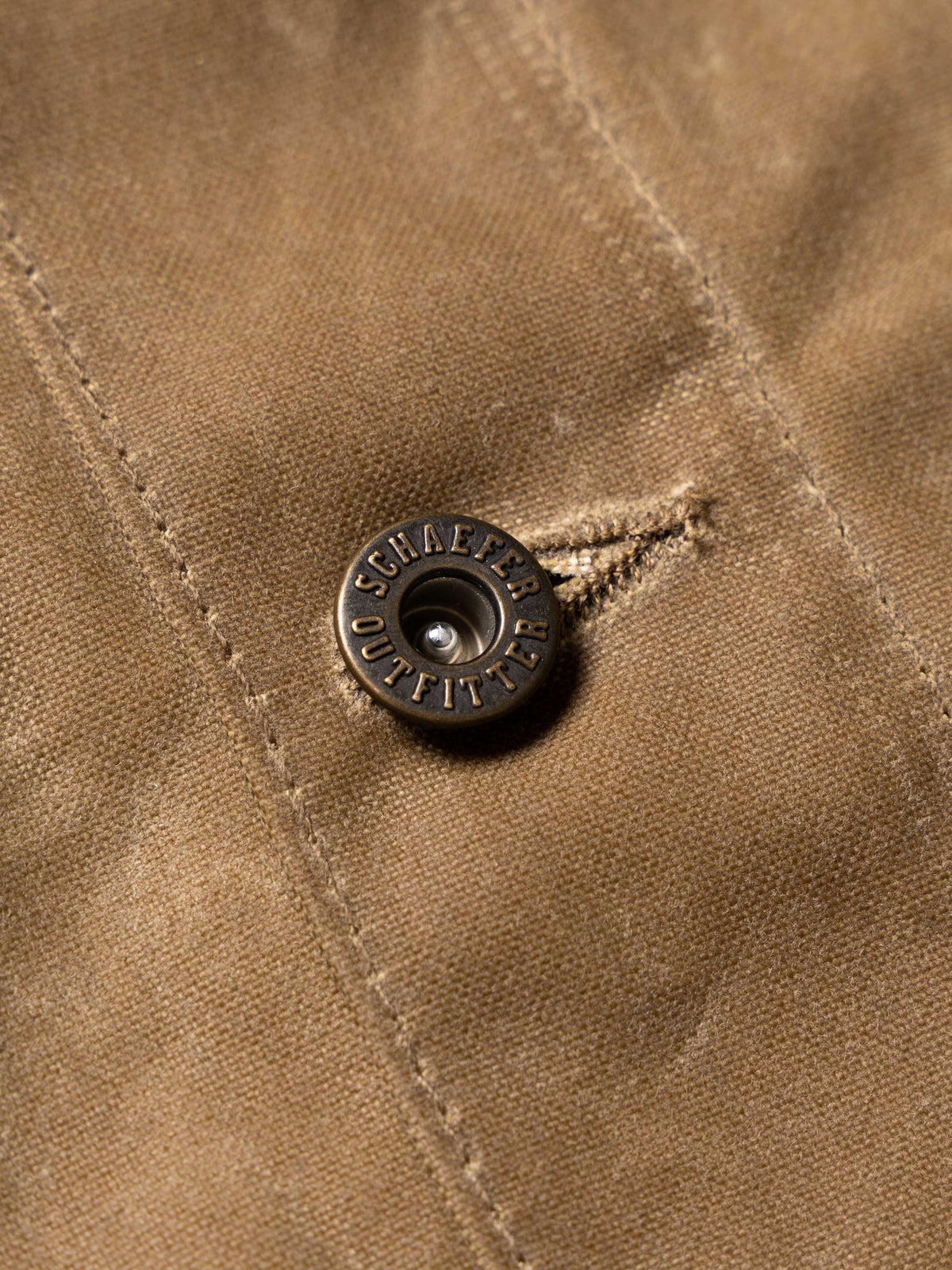 RangeWax® Mesquite brush jacket snap detail with brand button on sand fabric