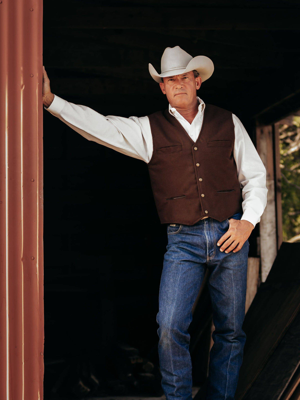 Men's chocolate-brown cowboy vest worn over a white shirt with a hat